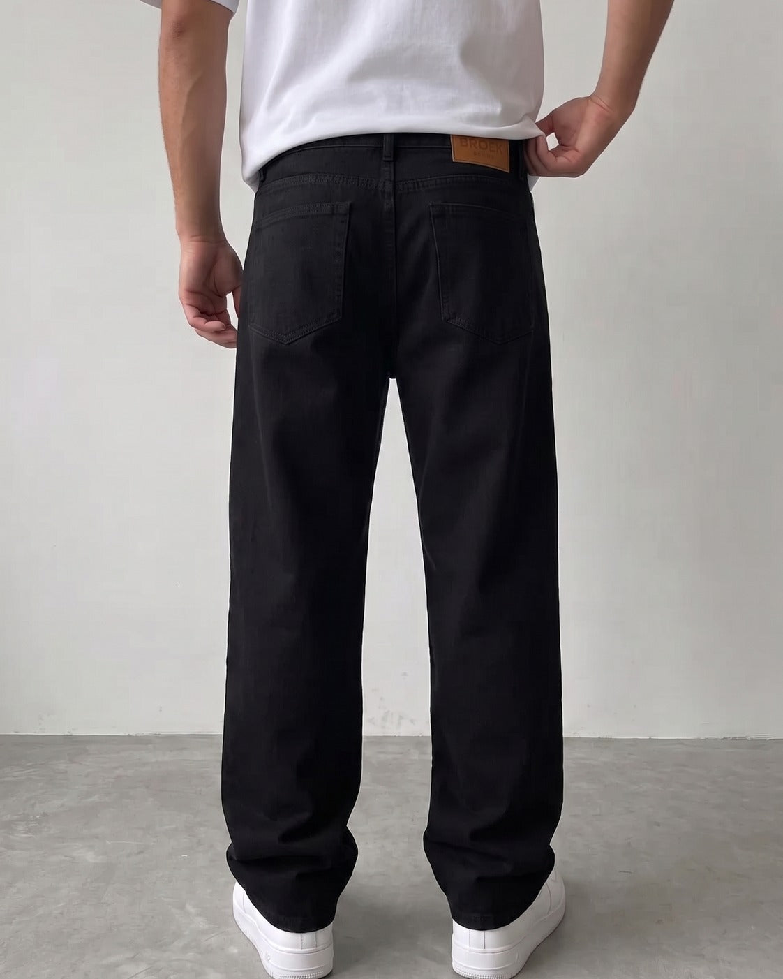 BROEK jet black relaxed fit denim jeans - back view with leather patch
