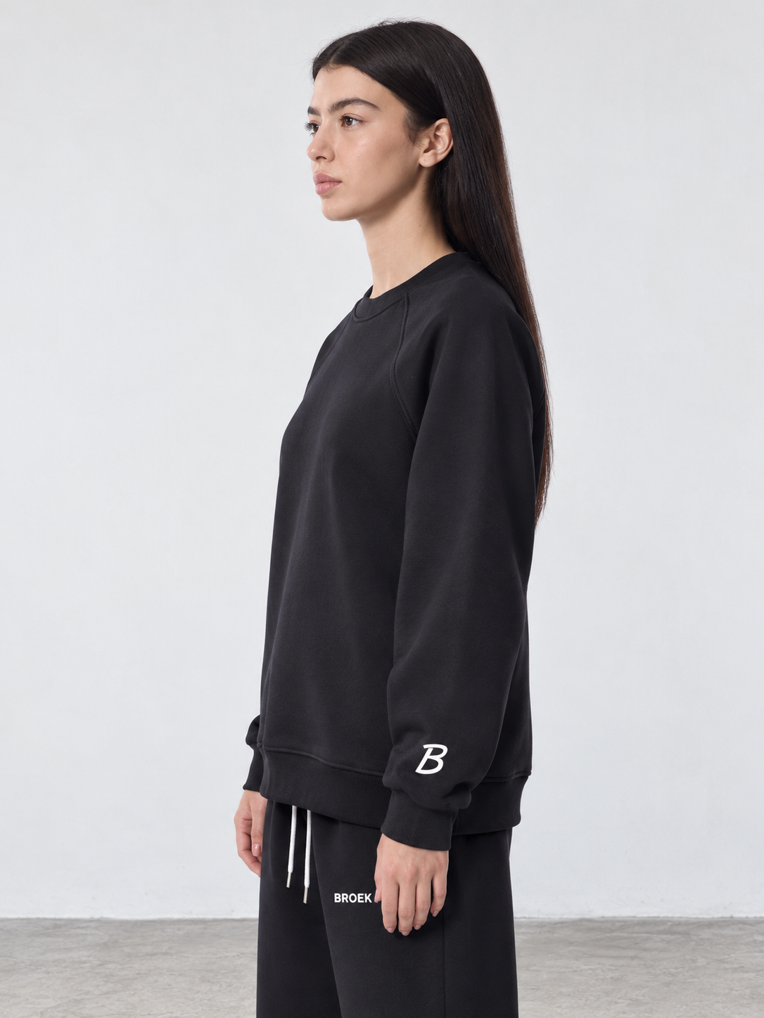 BROEK Raglan Crewneck – Black — كادر ¾ جانبي — السويتشيرت
