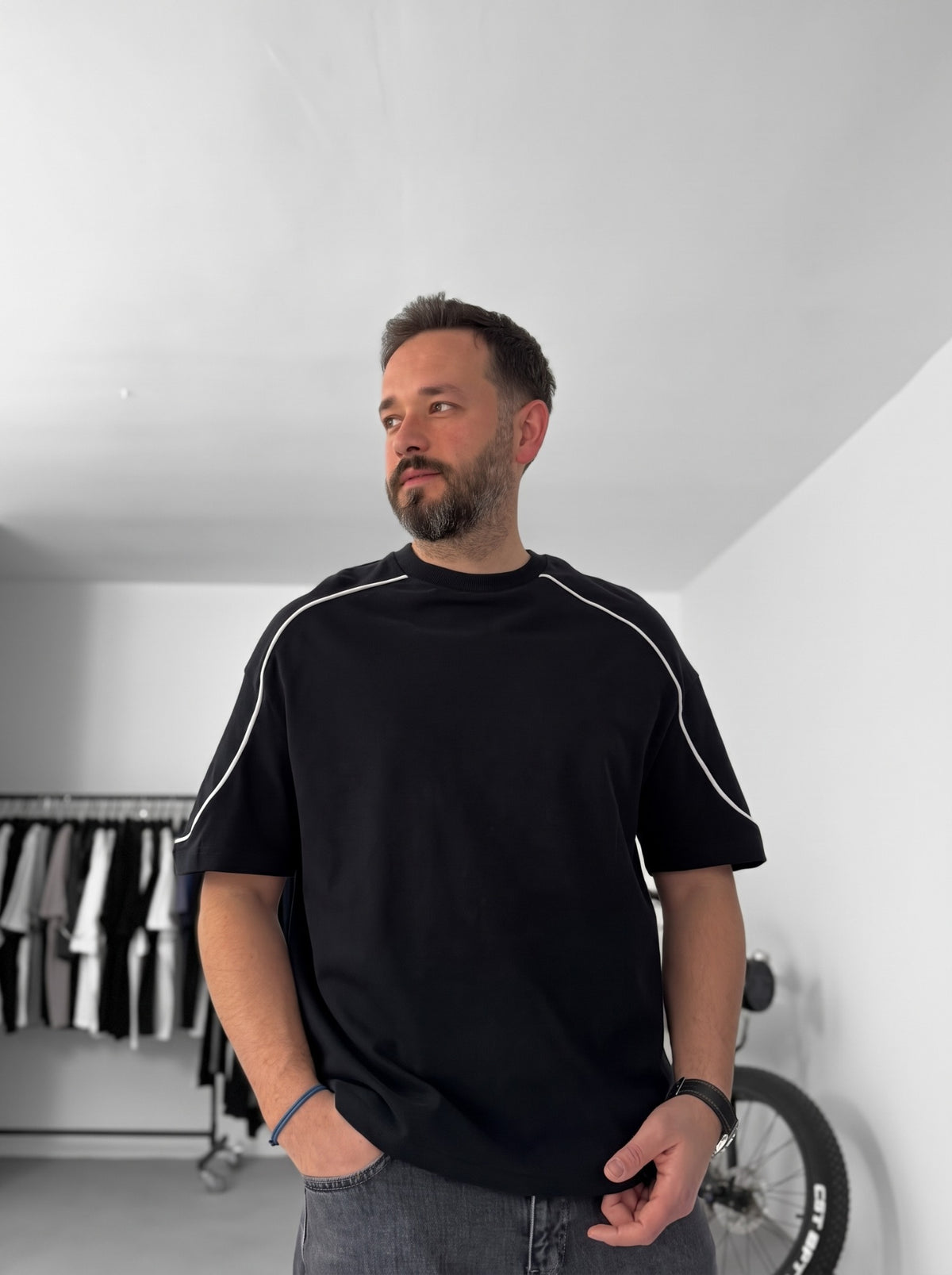 BROEK black oversized crew-neck T-shirt on model, wider view showing the white shoulder and sleeve piping.