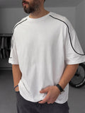 BROEK white oversized T-shirt with black contrast piping, three-quarter model view.