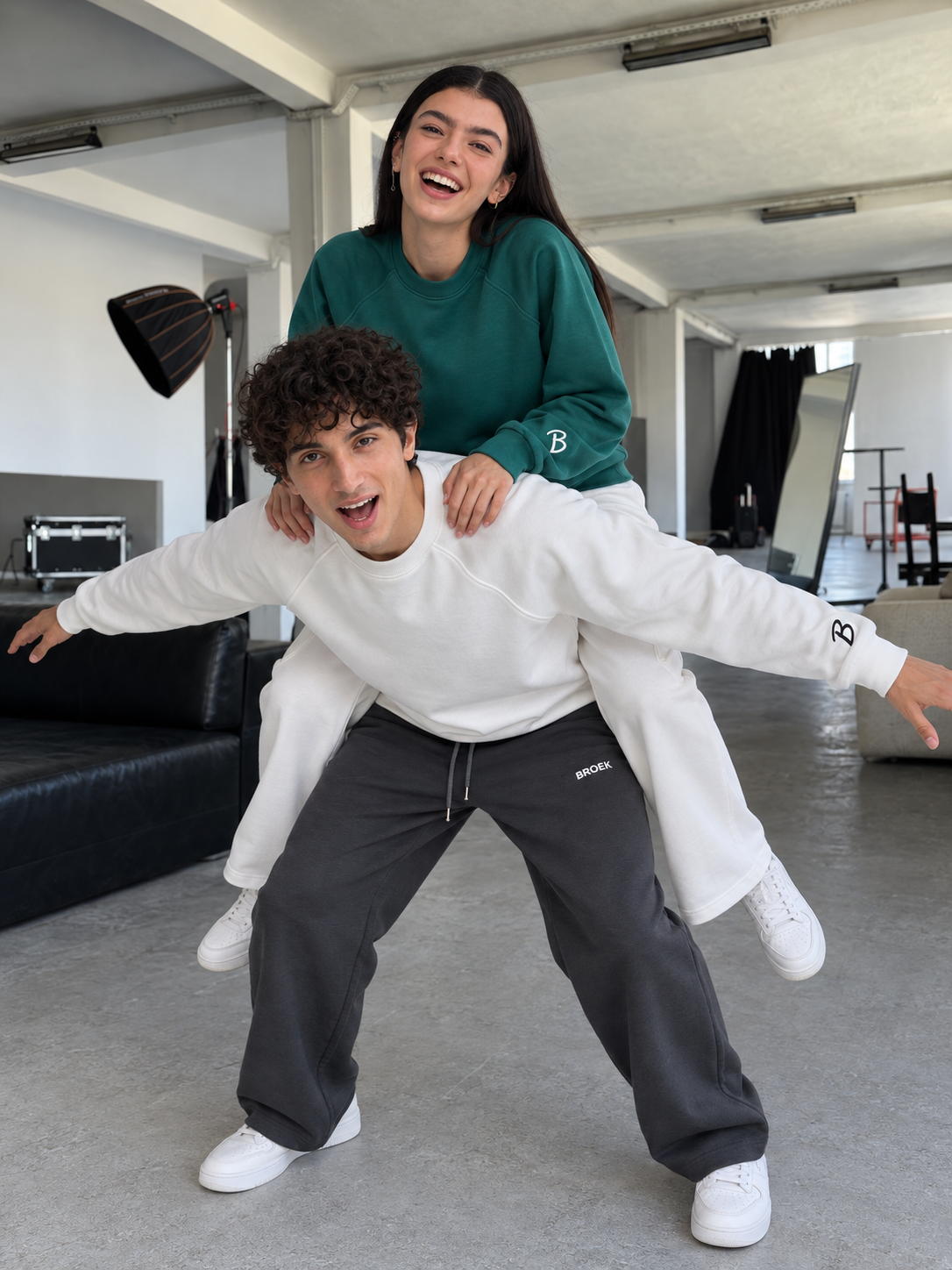Two BROEK models laughing in boxy crewneck and baggy sweatpants sets